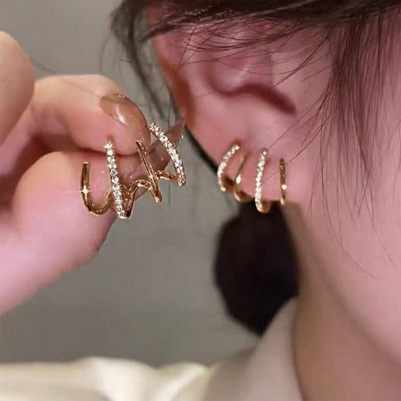 Close-up van glimmende zilveren klauw oorbel met zirkonia stenen voor dames, geeft een piercing look.