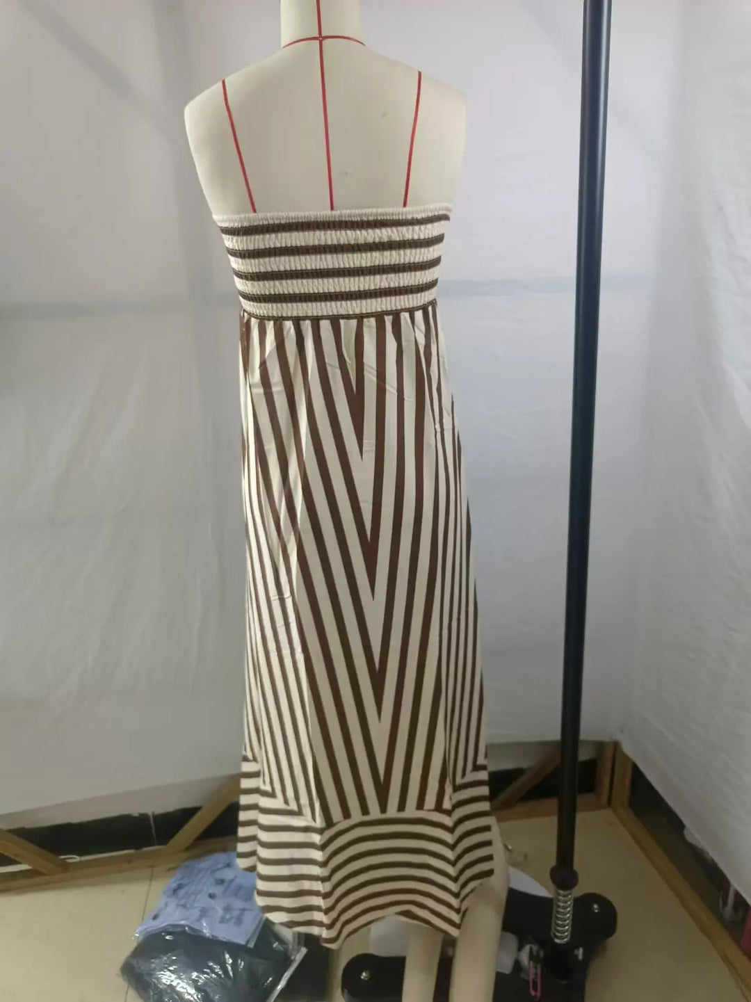 Dames strapless maxi-jurk met subtiel gestreept patroon, creëert een elegante en modieuze vakantielook.
