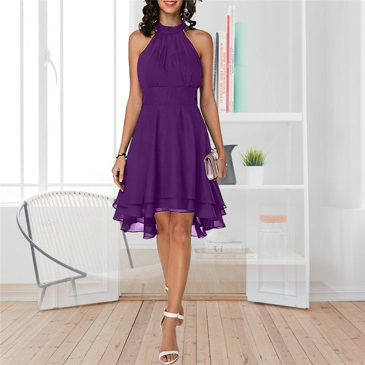 Achteraanzicht van de elegante dames halterjurk: mouwloos chiffon midi model met open rug detail en slim fit.