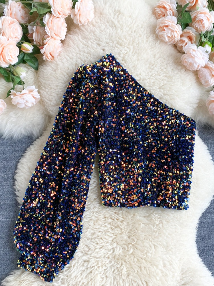 Detail van glanzende pailletten op deze modieuze dames glitter one-shoulder top.