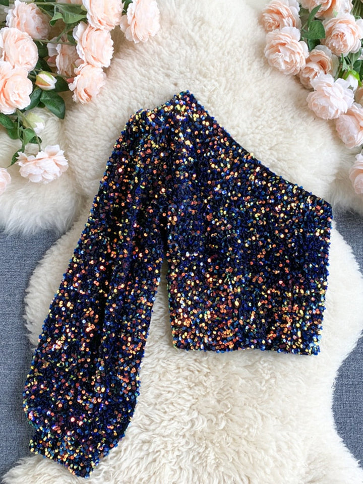 Detail van glanzende pailletten op deze modieuze dames glitter one-shoulder top.