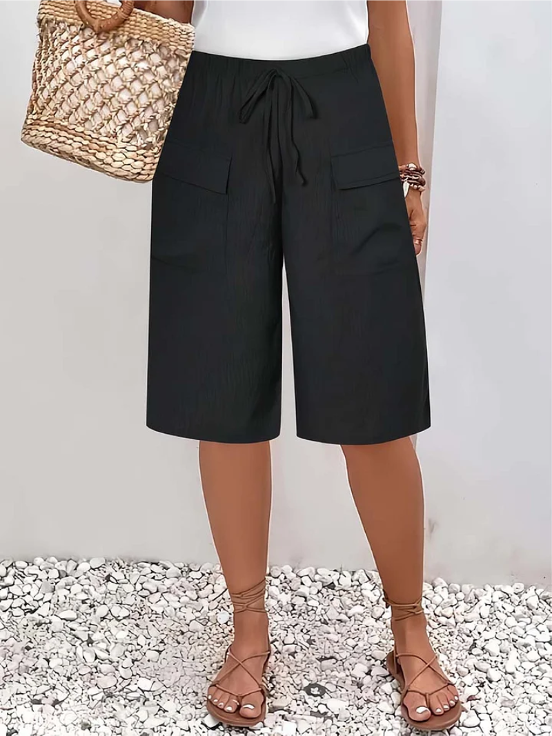 Modieuze zwarte dames shorts met zakken, veelzijdig voor lente en zomer. Stijlvolle ontspannen pasvorm.