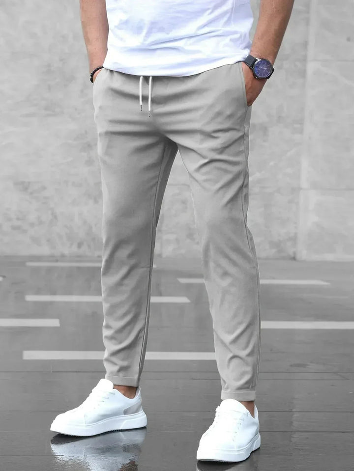 Heren slim fit broek met elastische tailleband, zijzakken en tapered pijpen. Modern en comfortabel.