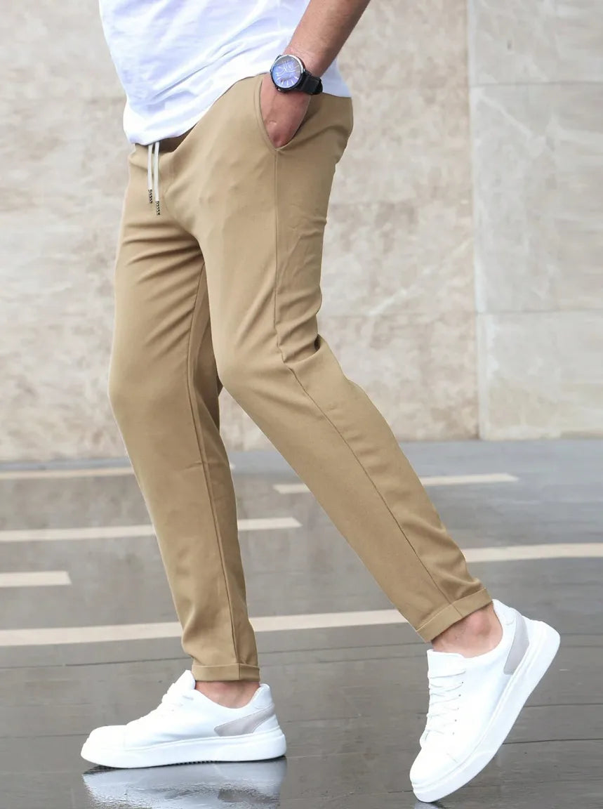 Casual heren slim fit stretchbroek met elastische tailleband, comfortabele tapered pijpen en moderne zijzakken.