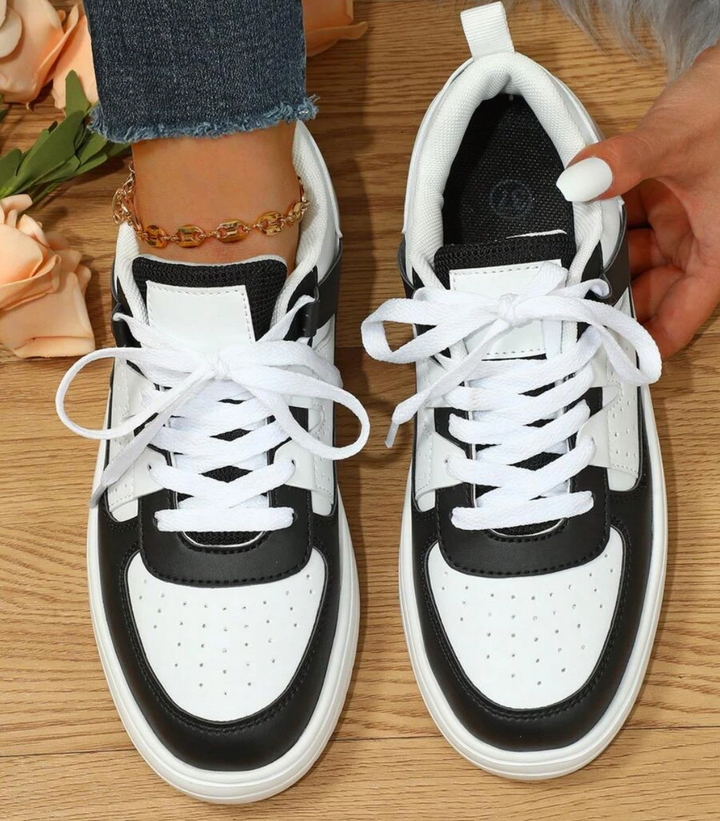 Vooraanzicht van modieuze Isabelle dames sneakers met witte veters en kleurrijke details.