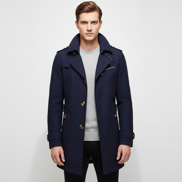 Heren trenchcoat met prominente schoudervullingen. Gestructureerd design voor een krachtige, moderne lange jas.