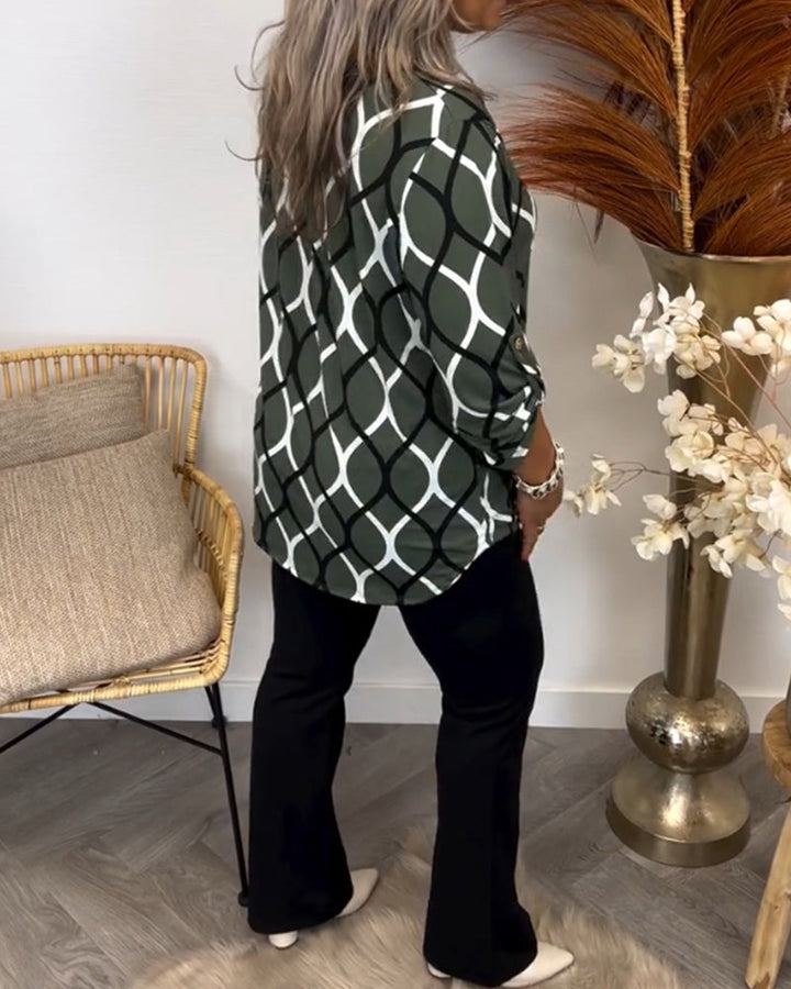 Model draagt casual dames blouse met grafische print, v-hals en driekwart mouw. Comfortabele loose fit.