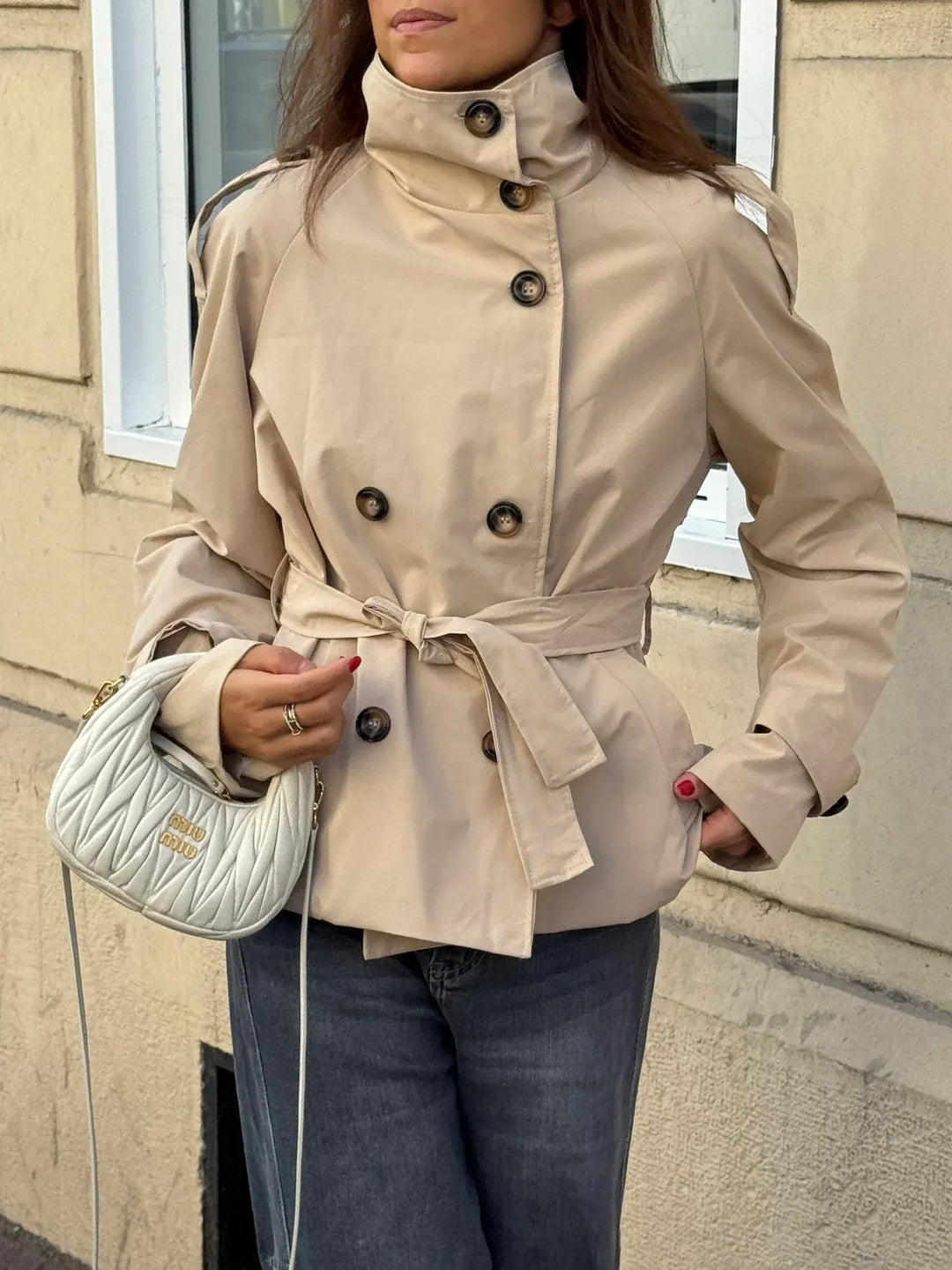 Beige getailleerde dames trenchcoat, waterafstotend en elegant voor elk weer. Klassieke herfstjas.