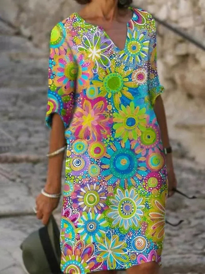 Kleurrijke dames zomerjurk met vrolijke bloemenprint. Comfortabele en stijlvolle lentejurk voor elke gelegenheid.