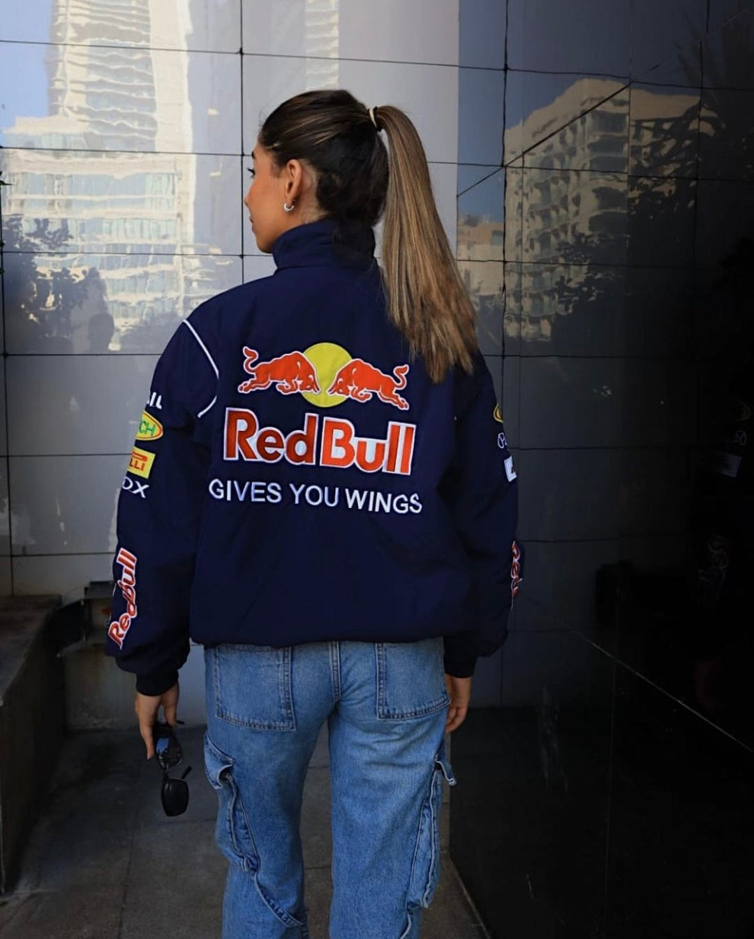 Model draagt donkerblauwe racingjas met hoge kraag, ideaal voor een sportieve look.