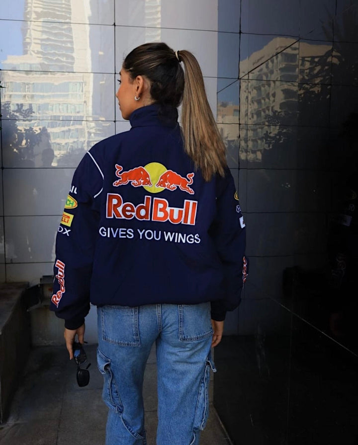 Model draagt donkerblauwe racingjas met hoge kraag, ideaal voor een sportieve look.