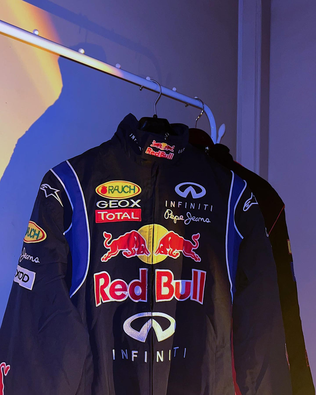 Donkerblauwe sportieve racingjas, unisex, met hoge kraag en ritssluiting, perfect voor streetwear.