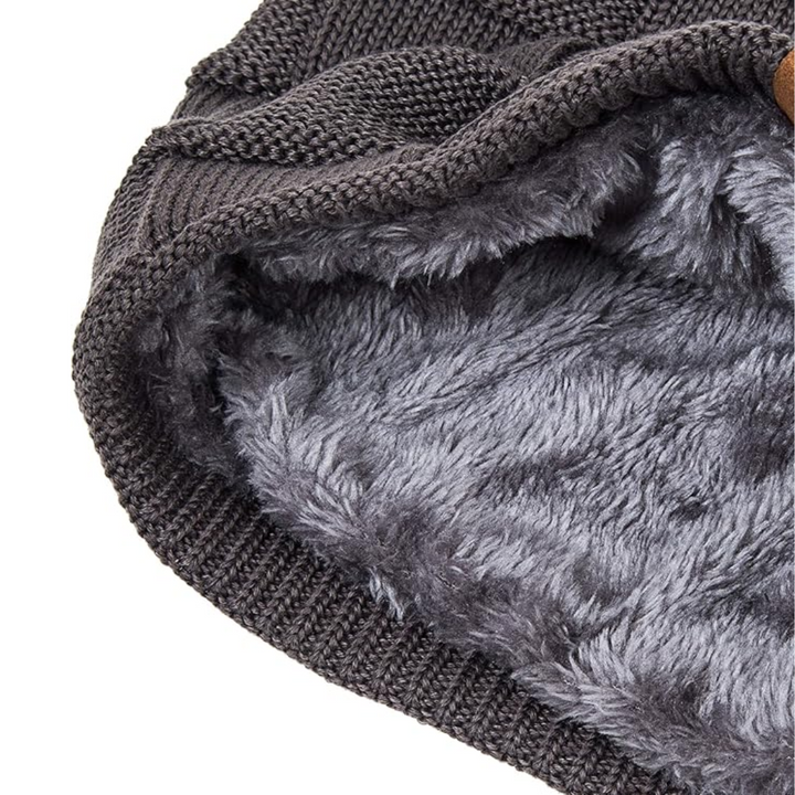 Model draagt een stijlvolle, warme gebreide beanie muts. Perfect voor dames en heren in de winter.
