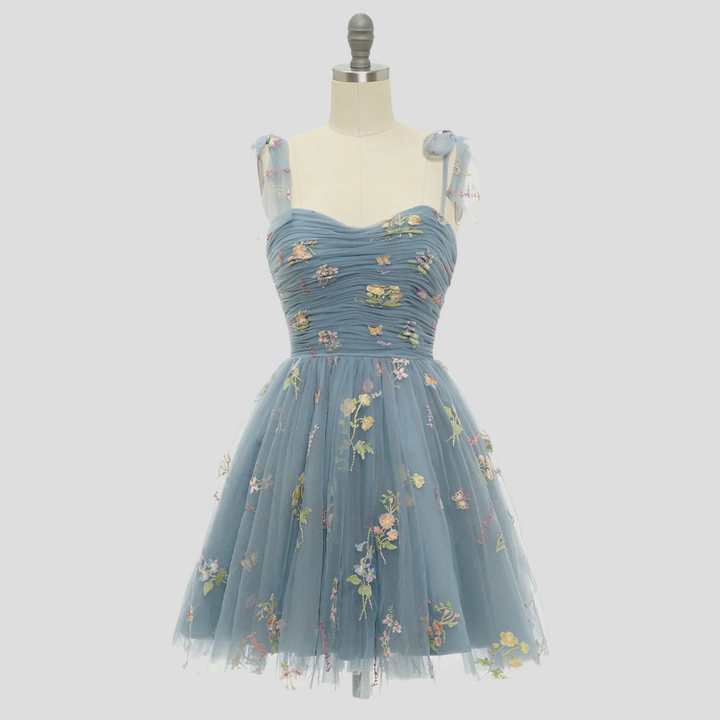Verfijnde damesjurk van tule, rijkelijk geborduurd, uitermate geschikt als elegante avondmode.