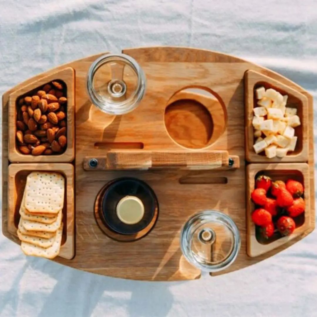 Compacte houten wijntafel met inkepingen voor wijnfles en glazen, handig voor elk outdoor uitje.