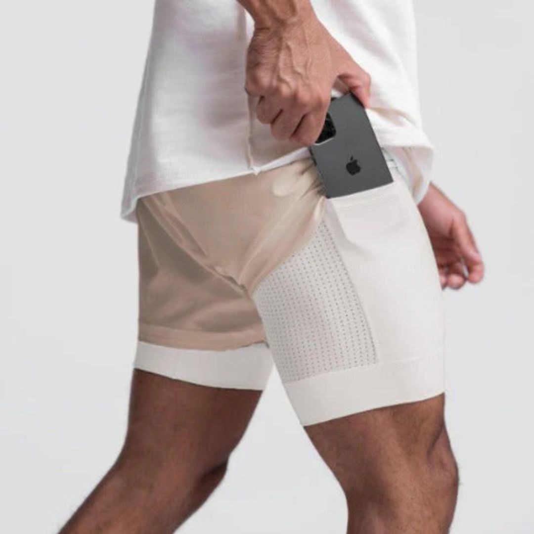 Man draagt de witte heren sportshort Carl tijdens fitness, toont bewegingsvrijheid.