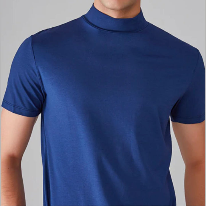 Man draagt strak heren T-shirt met hoge kraag, slim fit. Perfect voor een casual maar stijlvolle zomerlook.