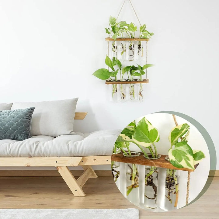Detail van wandhangende reageerbuis plantenbak met water en kleine plantjes; stijlvolle interieuraccessoire.