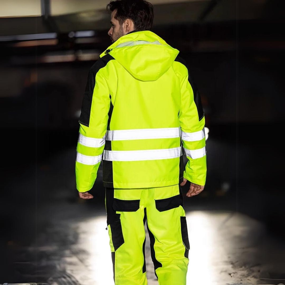 Zij-aanzicht van het reflecterende winter werkpak met diverse zakken, praktisch voor werkkleding.