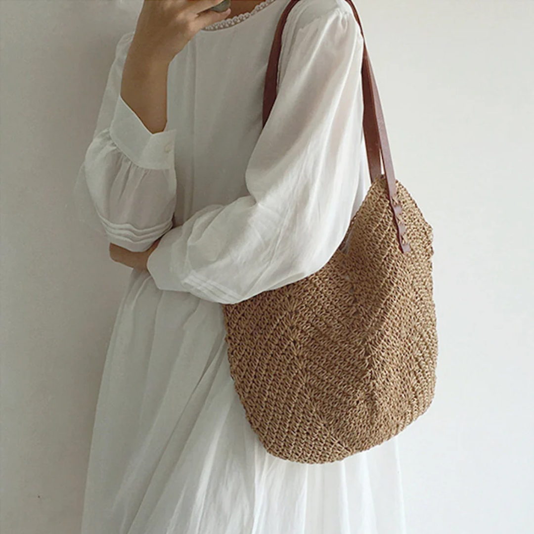 Ruime dames schoudertas met trendy geweven look, beschikbaar in wit en bruin. Perfect voor modebewuste vrouwen.