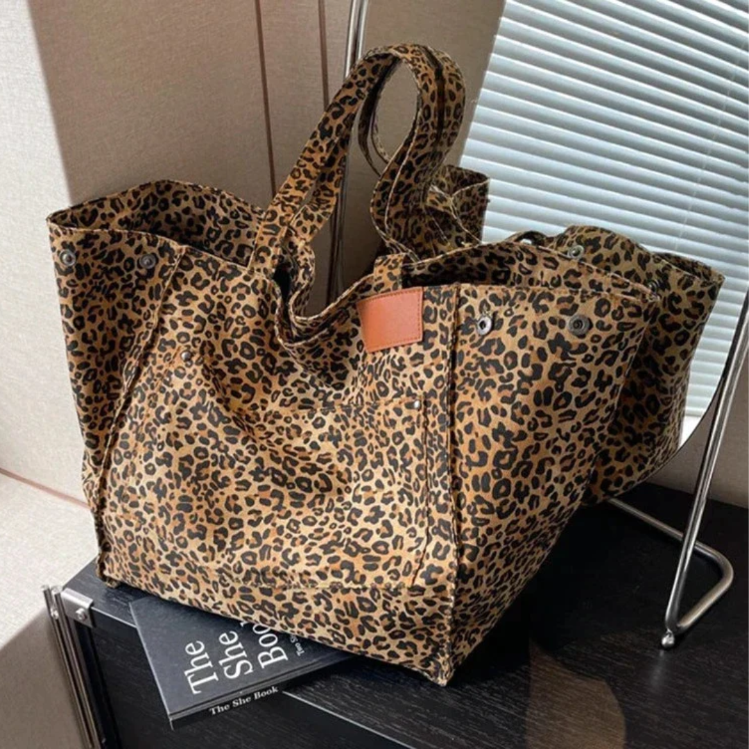 Elegante dames handtas met luipaardprint, toont de ruime vorm en het stijlvolle ontwerp.
