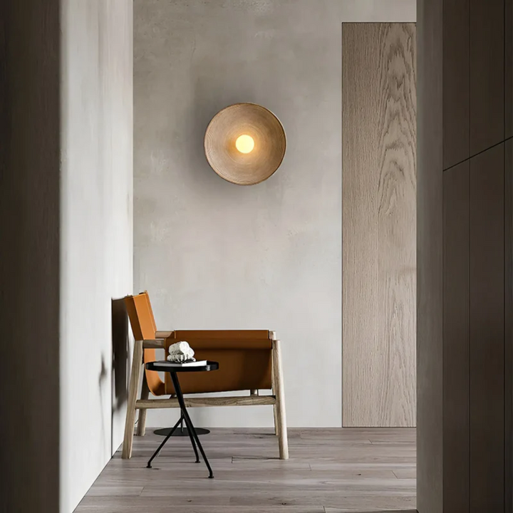 Unieke Japanse Wabi-Sabi wandlamp ZenGlow Disc, handgemaakt van glas en hars voor warme, rustgevende verlichting.