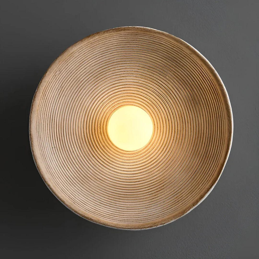Detail van de ZenGlow Disc wandlamp: textuur van glas en hars, warm wit licht voor een serene ambiance.