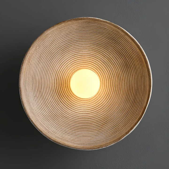 Detail van de ZenGlow Disc wandlamp: textuur van glas en hars, warm wit licht voor een serene ambiance.
