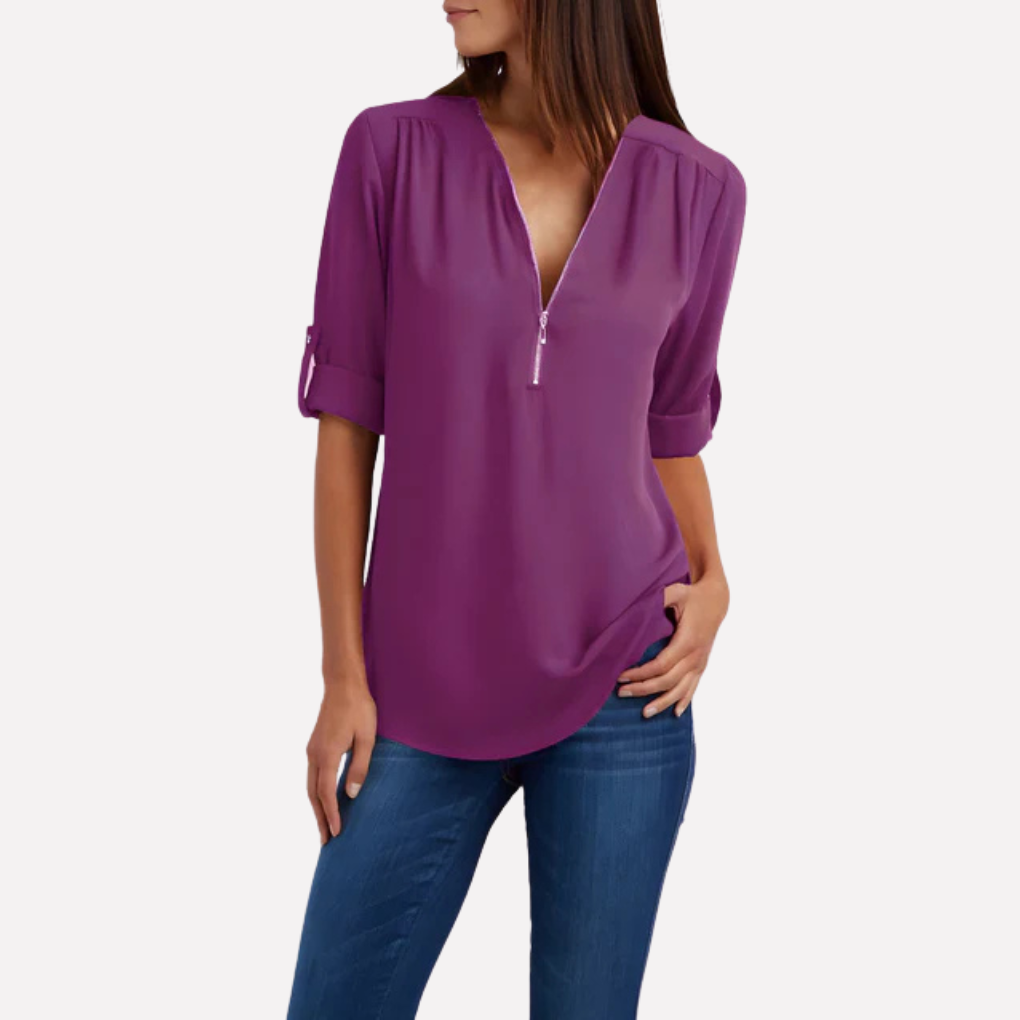 Model draagt een chique damesblouse met halve rits, straalt stijl en comfort uit.