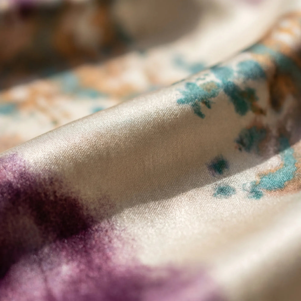 Wikkeljurk dames met levendige tie-dye waterverf print in paars/teal/goud, lange ballonmouwen en flatterende strikceintuur.