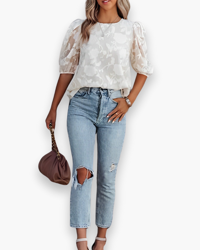 Close-up van de kenmerkende pofmouwen van deze moderne dames top. Een chic detail voor elke look.
