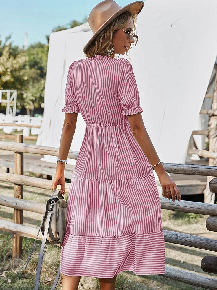 Midi gestreepte dames zomerjurk met korte mouwen. Casual V-hals jurk met knopen ideaal voor strand.
