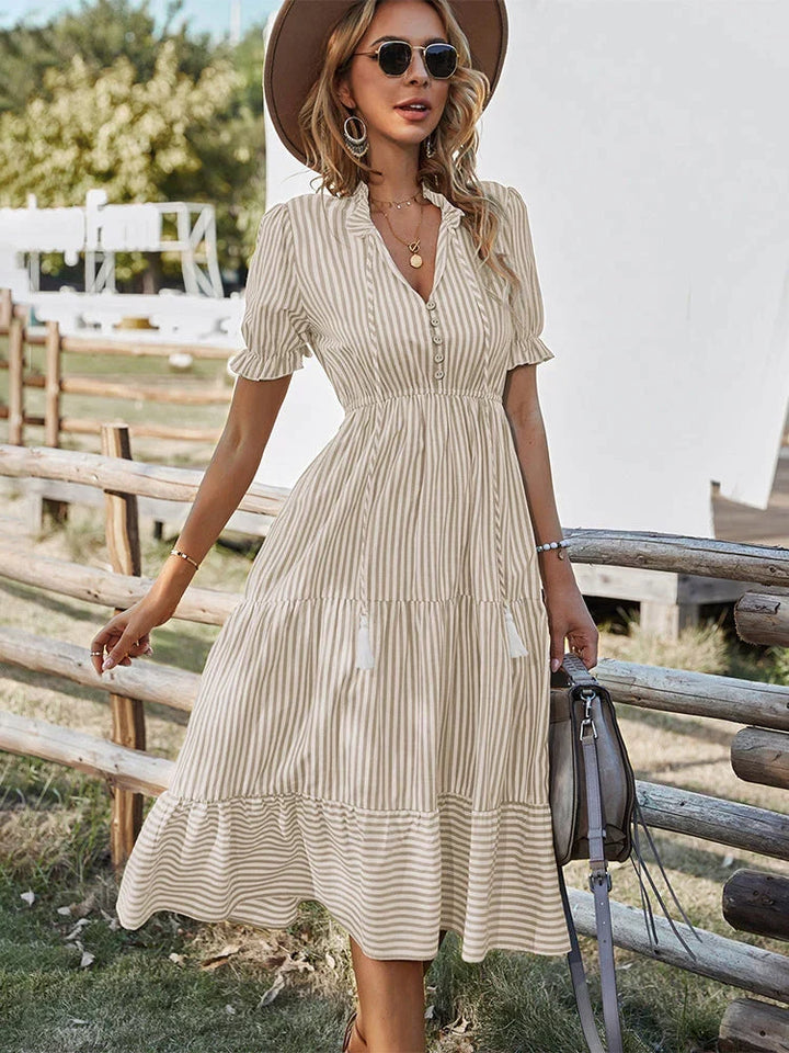 Veelzijdige gestreepte dames zomerjurk met korte mouwen. Casual midi jurk met knopen, perfect voor strand.