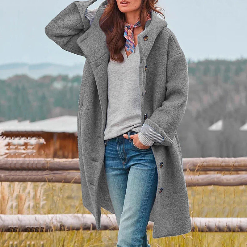 Comfortabele lange winterjas voor dames, modieus losvallend model met knoopsluiting en capuchon.