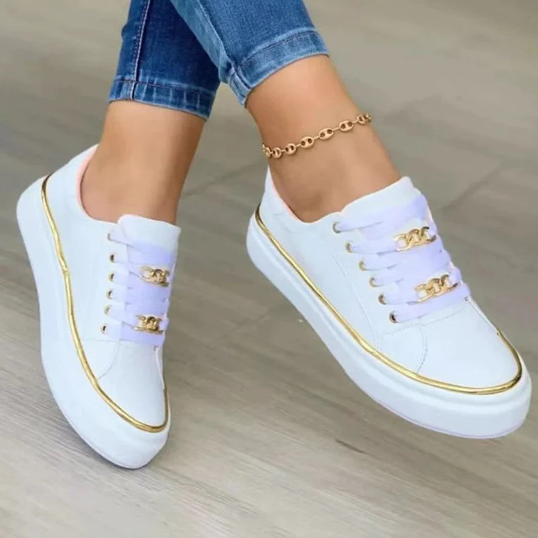 Stijlvolle witte damessneakers met gouden accenten, perfect voor dagelijks comfort en een trendy casual look.