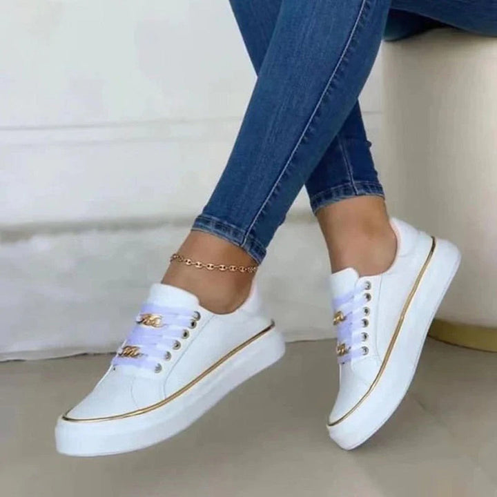 Trendy damessneakers met veters, witte zool en gouden accenten, bieden dagelijks comfort en stijl voor elke vrouw.