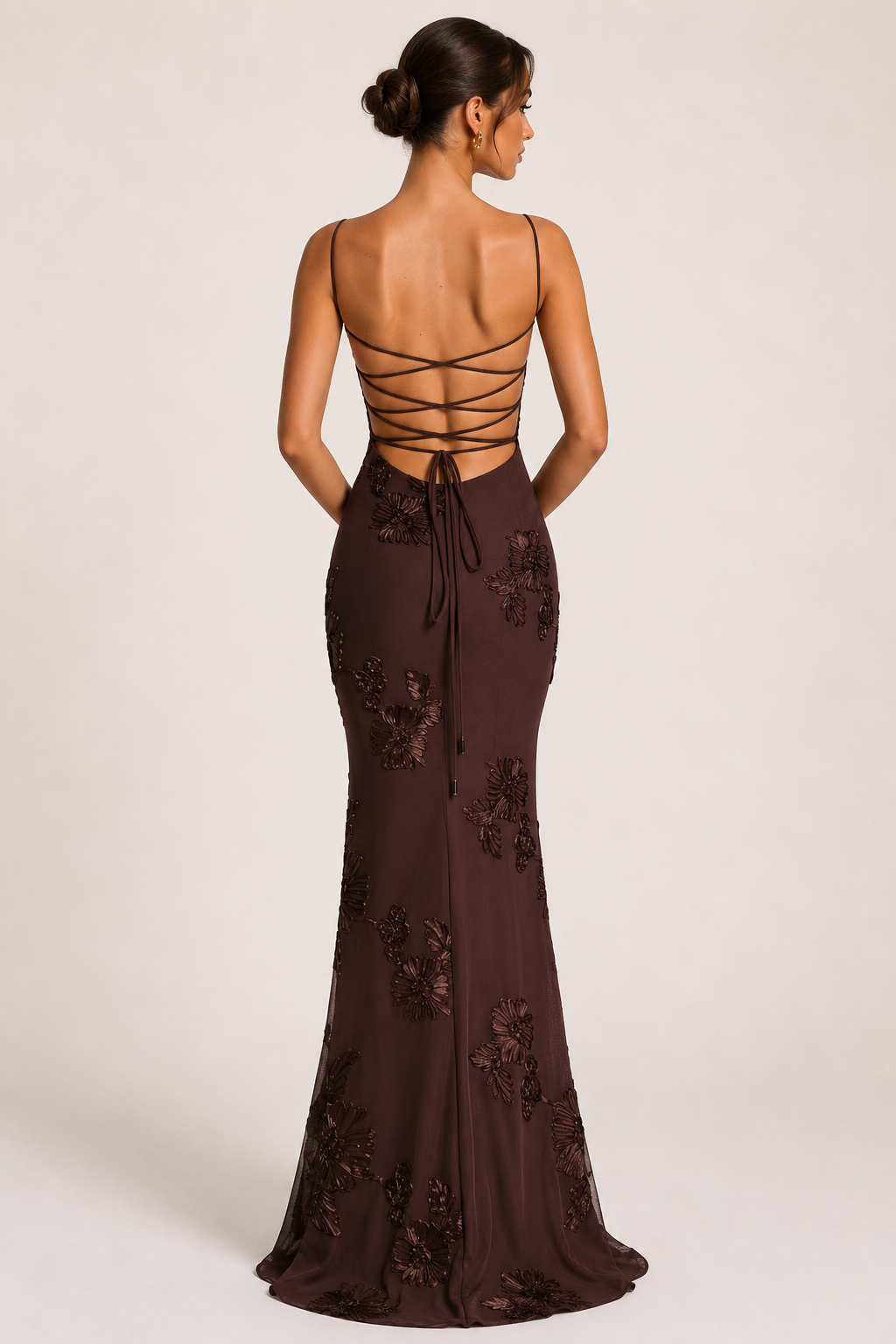 Detailfoto van de bruine elegante maxi-jurk; toont bloemenborduursel en de kenmerkende corsetlook op het lijfje.