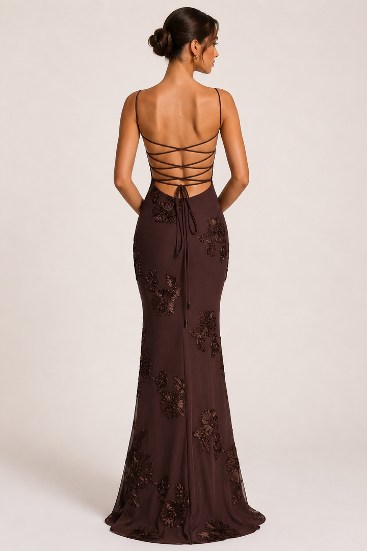 Detailfoto van de bruine elegante maxi-jurk; toont bloemenborduursel en de kenmerkende corsetlook op het lijfje.