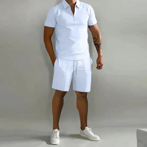 Man draagt complete heren zomerset: ademende polo en korte broek. Geniet van stijlvol comfort en casual chic in de zomer.