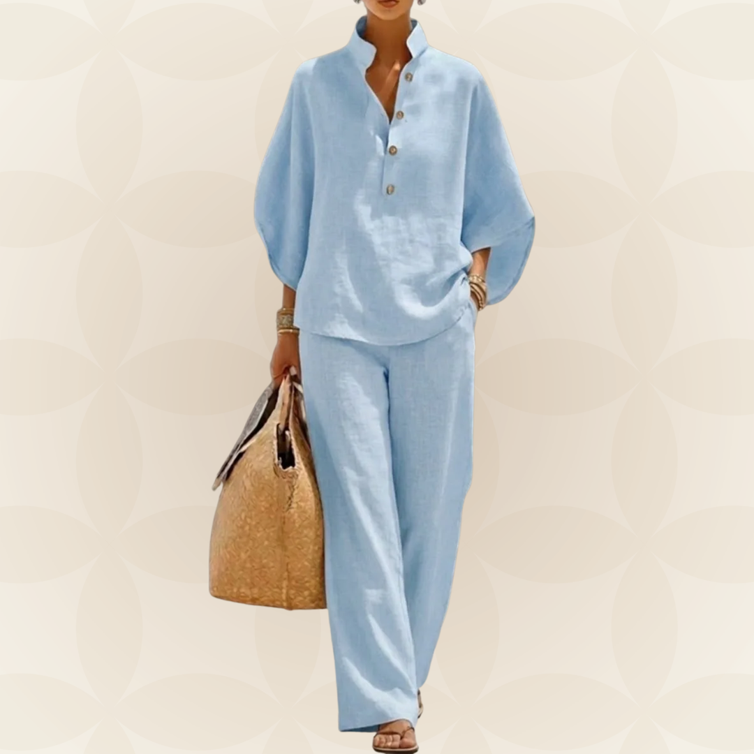 Fotomodel toont een moderne 2-delige dames zomer set. Wijde broek en blouse met linnen look.