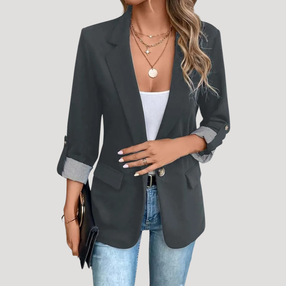 Trendy blauwe damesblazer, getailleerd en met opgerolde mouwen, voor een stijlvolle zakelijke of casual look.
