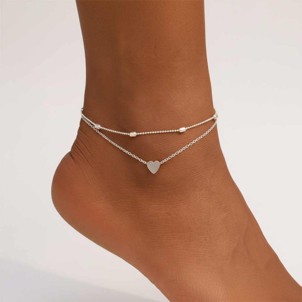 Gedetailleerd zilveren enkelbandje van sterling zilver met dubbele ketting en subtiel hartje.