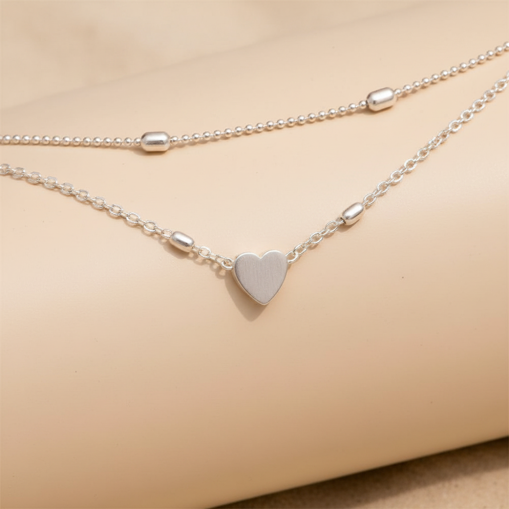 Dames enkelbandje met hartbedel en dubbele ketting. Modern zilveren sieraad, ideaal voor elke outfit.