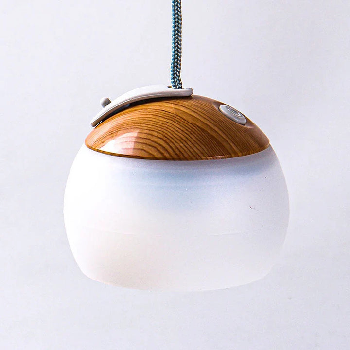 Draagbare HeritageGlow vintage LED buitenlamp, hangend in een tent, zorgt voor warme sfeerverlichting.