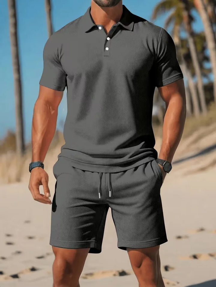 Zomerse heren kleding: lichtblauwe V-hals polo en witte shorts, ideaal voor een relaxte dag.