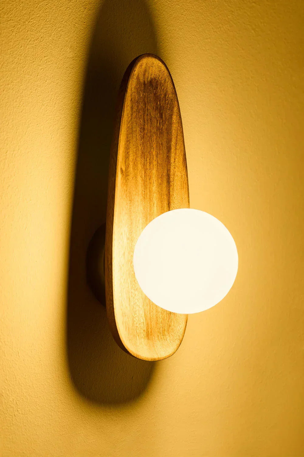 Modern design wandlamp van acaciahout met opaalglas, creëert een natuurlijke en warme sfeer.