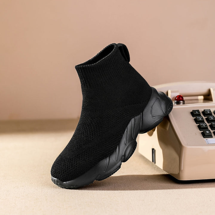 Kind zit comfortabel met ademende kinder sokschoenen aan, klaar om zorgeloos te spelen.