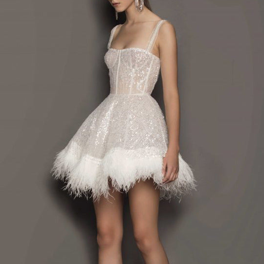 Close-up van een witte feestjurk met schitterende pailletten, ideaal als avondjurk of elegante cocktailjurk.