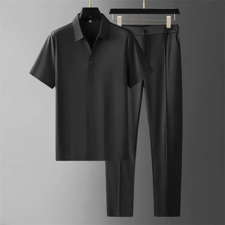 Man poseert in stijlvolle tweedelige set: polo & pantalon. Luxe heren zomerkleding, casual outfit.