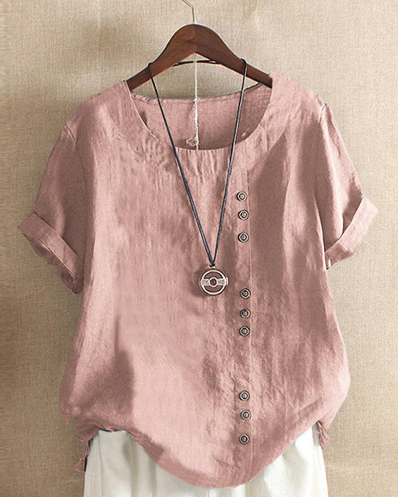 Vooraanzicht van de modieuze dames blouse met korte mouwen, ronde hals en knoopdetails.